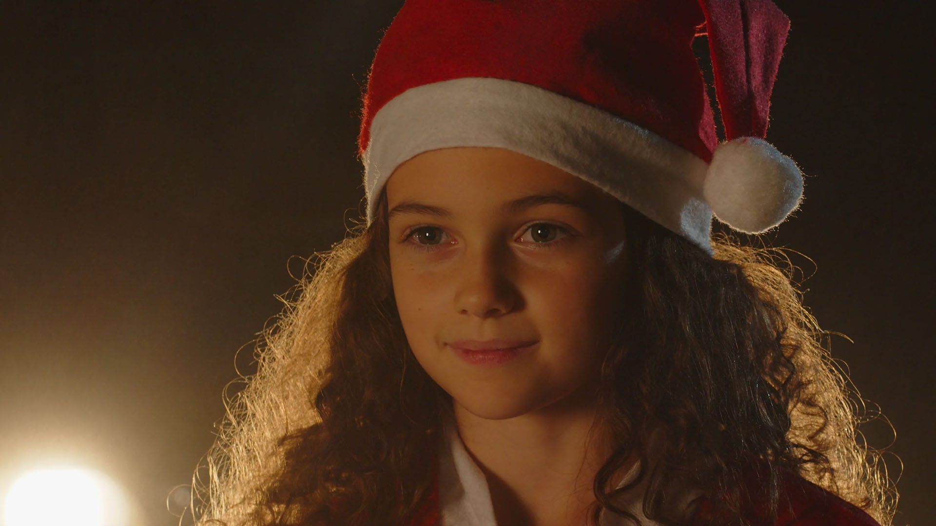 Une des protagonistes du film avec un chapeau de Noël regarde au loin Fille Noël
